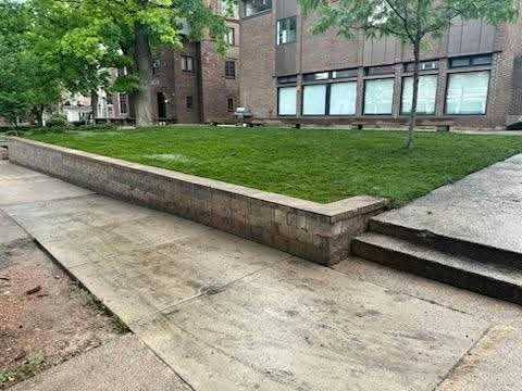 New sod laid on a raised lawn area behind a block retaining wall